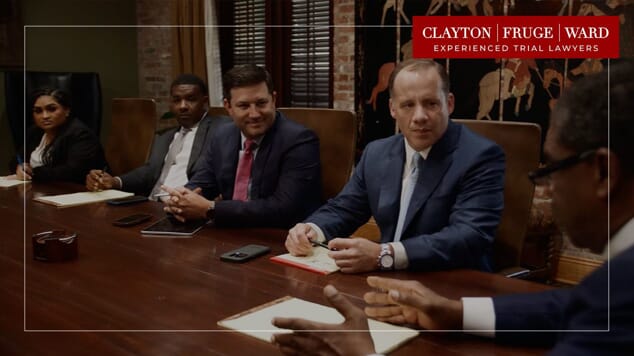 attorneys sitting at table with logo on picture